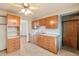 View of the kitchen showcases wood cabinets, a ceiling fan, and vintage flooring at 8012 Zuni St, Denver, CO 80221