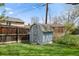 A small blue shed and wooden fence stand on a lush green lawn in the back yard at 8012 Zuni St, Denver, CO 80221