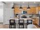 Modern kitchen with wooden cabinets, stainless steel appliances, pendant lighting, and an island with barstool seating at 2086 Wagon Wheel Aly, Brighton, CO 80601