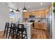 Bright kitchen with wooden cabinets, stainless steel appliances, an island with seating, and hardwood flooring at 2086 Wagon Wheel Aly, Brighton, CO 80601