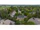 Aerial view of a green home with trees, showing a quiet neighborhood and a glimpse of mountains in the distance at 2240 Summitview Dr, Longmont, CO 80504