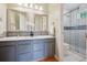 Bathroom featuring dual sinks with framed mirrors, a glass door shower, and white tiling at 2240 Summitview Dr, Longmont, CO 80504