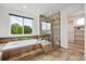 Bathroom featuring a soaking tub with tiled surround and a walk-in shower at 2240 Summitview Dr, Longmont, CO 80504