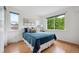 Bright bedroom with wood floors, ample natural light and comfortable blue bedding at 2240 Summitview Dr, Longmont, CO 80504