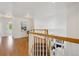 Upstairs hallway with hardwood floors and a view of the living room below at 2240 Summitview Dr, Longmont, CO 80504