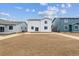 Newly constructed back yard with an empty lot ready for landscaping and a view of adjacent homes at 1416 Orchard St, Brighton, CO 80601