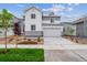 Charming two-story home with a two-car garage, landscaped front yard, and attractive white and gray exterior at 1416 Orchard St, Brighton, CO 80601