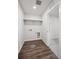 Functional laundry room with wood-look floors, overhead shelving, and connections for a washer and dryer at 1416 Orchard St, Brighton, CO 80601