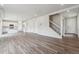 Open-concept living area with hardwood floors, bright white walls, and staircase access at 1416 Orchard St, Brighton, CO 80601