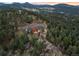 Overhead view of a large Gathering home on a lot surrounded by evergreen trees at 21798 Wagon Rim Trl, Morrison, CO 80465