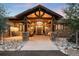 An elegant front porch features stone columns, wood detailing, and a swing creating a welcoming entrance to the home at 21798 Wagon Rim Trl, Morrison, CO 80465