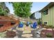 Relaxing backyard with a gravel firepit area, Adirondack chairs, lush landscaping, and wood fencing at 6248 E Mineral Pl, Centennial, CO 80112