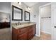 Double sink vanity in a bathroom features granite countertops and dark wood cabinetry, adjacent to a doorway at 6248 E Mineral Pl, Centennial, CO 80112