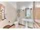 Stylish powder room with pedestal sink, decorative mirror, and ski-themed wall art at 16713 W Archer Ave, Golden, CO 80401