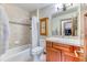 A charming bathroom featuring a shower-tub combo, a wood vanity, and tile flooring at 16713 W Archer Ave, Golden, CO 80401