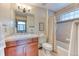 A cozy bathroom with a shower-tub combo, mosaic tile accents, and a wood vanity at 16713 W Archer Ave, Golden, CO 80401