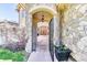 Inviting stone archway leading to an elegant wood double door entrance at 16713 W Archer Ave, Golden, CO 80401