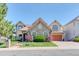 Charming stone-accented home featuring a tile roof, manicured lawn and mature trees at 16713 W Archer Ave, Golden, CO 80401