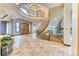 Spacious foyer with travertine floors, grand staircase, and elegant chandelier at 16713 W Archer Ave, Golden, CO 80401