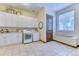 Functional laundry room with white cabinets, washer, dryer, and tiled floor at 16713 W Archer Ave, Golden, CO 80401