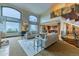 Bright, open living room showcasing the staircase, fireplace, kitchen, and expansive windows at 16713 W Archer Ave, Golden, CO 80401