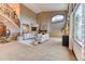 Spacious living room featuring a staircase, fireplace, large windows, and neutral-toned sofas at 16713 W Archer Ave, Golden, CO 80401