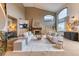 Bright living room boasts soaring ceilings, large windows, a fireplace, and neutral-toned sofas and decor at 16713 W Archer Ave, Golden, CO 80401