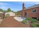 Backyard of a brick home, including a greenhouse, patio, shed, and lots of yard space at 2065 Leyden St, Denver, CO 80207