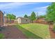 A large backyard featuring a storage shed, green grass, and mulch beds, perfect for gardening and outdoor activities at 2065 Leyden St, Denver, CO 80207