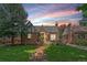 A quaint red brick Tudor-style house with a well-manicured lawn and inviting front patio at 2065 Leyden St, Denver, CO 80207