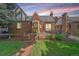 Charming Tudor home with brick exterior, beautiful landscaping, and cozy front porch at 2065 Leyden St, Denver, CO 80207