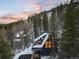 Stunning exterior of a modern mountain home surrounded by snow-covered trees at dusk at 6365 Highway 9, Breckenridge, CO 80424