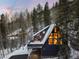 Exterior angle of mountain home surrounded by tall pine trees and a snow-covered yard at 6365 Highway 9, Breckenridge, CO 80424