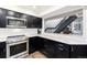 Modern kitchen with stainless steel appliances, black cabinets, and a window offering a view to the living space at 6365 Highway 9, Breckenridge, CO 80424