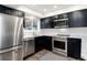 Modern kitchen featuring stainless steel appliances, black cabinets, and a window offering natural light at 6365 Highway 9, Breckenridge, CO 80424