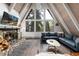 Living room with a stone fireplace, a blue sofa and wooden A-frame architecture at 6365 Highway 9, Breckenridge, CO 80424