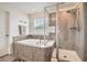 Bathroom with soaking tub, tiled shower, and bright natural light at 16043 Fillmore St, Thornton, CO 80602