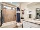 Well-lit bathroom featuring a shower with decorative tiling and a contrasting patterned shower curtain at 16043 Fillmore St, Thornton, CO 80602