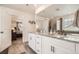 Bathroom featuring double sinks, granite countertops, white cabinets, and a walk-in shower at 16043 Fillmore St, Thornton, CO 80602