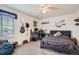 Bedroom with a bed, desk, a mounted guitar, and carpeted floors at 16043 Fillmore St, Thornton, CO 80602