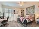 A cozy bedroom featuring a metal bedframe, natural light from the window, a desk, and ivy wall decor at 16043 Fillmore St, Thornton, CO 80602