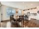 Open dining area flowing into a modern kitchen with hardwood floors and natural light at 16043 Fillmore St, Thornton, CO 80602