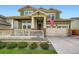 Inviting home featuring a covered porch, two-car garage and beautiful green lawn at 16043 Fillmore St, Thornton, CO 80602
