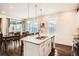 Open kitchen with granite island, stainless appliances, and adjacent dining area with sliding doors to outdoor space at 16043 Fillmore St, Thornton, CO 80602