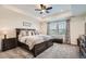 Spacious main bedroom featuring tray ceiling, large bed, carpeting, and a bench seat beneath the window at 16043 Fillmore St, Thornton, CO 80602