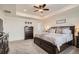 Main bedroom showcasing tray ceiling, a large bed, a dresser, and soft carpet, creating a serene and inviting space at 16043 Fillmore St, Thornton, CO 80602