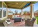 Cozy covered patio featuring comfortable outdoor seating, a fire pit table, and a view of the backyard at 16043 Fillmore St, Thornton, CO 80602