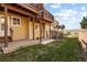 Exterior view of a backyard featuring a grassy area and outdoor patios with brown trim at 1747 High Plains Ct, Superior, CO 80027