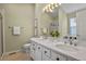 Bright bathroom featuring dual sinks, a large mirror, and a shower with a glass door at 1747 High Plains Ct, Superior, CO 80027