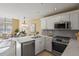 Well-equipped kitchen with stainless steel appliances, white cabinets, and elegant countertop at 1747 High Plains Ct, Superior, CO 80027
